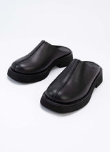 Lade das Bild in den Galerie-Viewer, Exklusive Leder-Clogs mit geschlossener Front und offener Hinterkappe aus schwarzem Leder. Optisches Highlight ist die prägnante Mittelnaht, die vertikal über den Schaft verläuft. Die Mules sind hautfreundlich mit schwarzem Leder gefüttert und sorgen so allzeit für ein frisches Fußklima. Die Laufsohle ist leicht erhöht und ebenfalls schwarz.