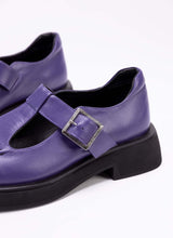 Lade das Bild in den Galerie-Viewer, Detailaufnahme eines Lederschuhs in der Farbe lila. Das Modell nennt sich Mary Jane und verfügt über die für diesen Schuhtyp charakteristischen Details wie den T-Steg und die Aussparungen auf dem Fußrücken. Die Laufsohle ist schwarz. Das Lederfutter ist ebenfalls schwarz.