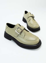 Lade das Bild in den Galerie-Viewer, Ein Paar Halbschuhe aus zertifiziertem Glattleder. Dieses Modell eignet sich für alle Geschlechter und hält sich nicht an Trends. Es handelt sich um einen sogenannten Monk mit einer Schnalle. Die besondere Farbe, ein Pastellgrün, die dezente Sohle mit Plateau und die Ziernaht auf der Front unterstreichen den nicht alltäglichen Charakter dieses Schuhs.