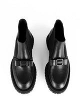 Lade das Bild in den Galerie-Viewer, Chelseaboot aus Leder in schwarz mit dekorativem Schleifendetail, welches sich über den Spann schmiegt. Eine ausgeprägte Laufsohle umrahmt den Schaft und schafft einen Kontrast zu dem verspielt-femininen Schleifendekor.