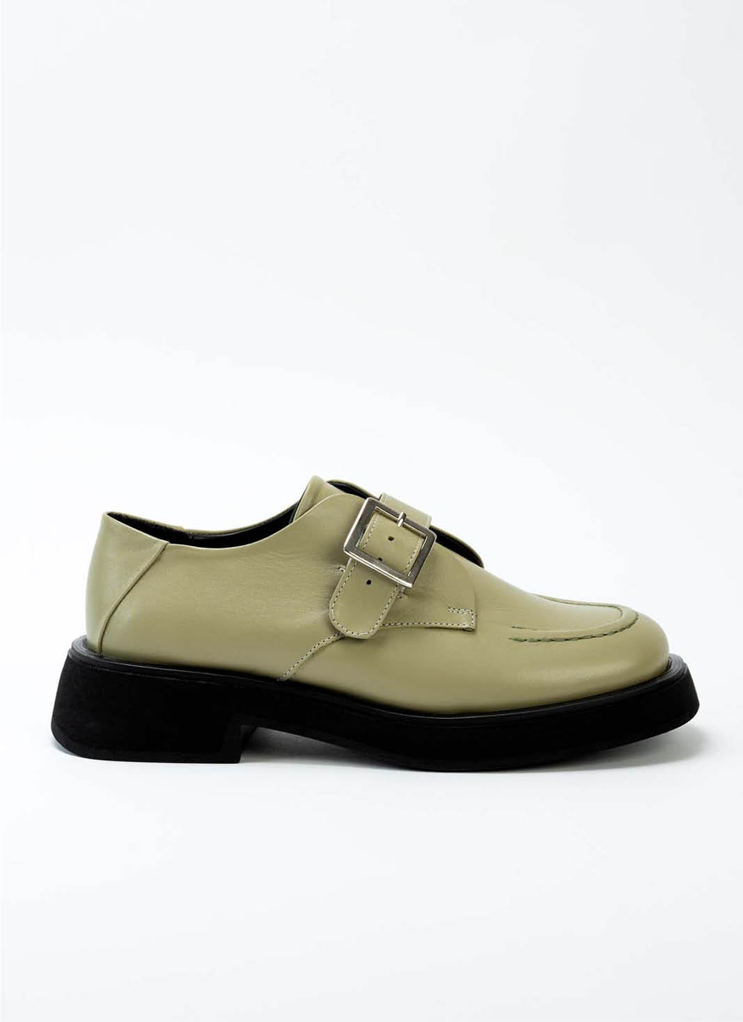 Lindgrüner Lederschuh mit Monk-Schnalle mit schwarzer Laufsohle und dezentem Plateau. 