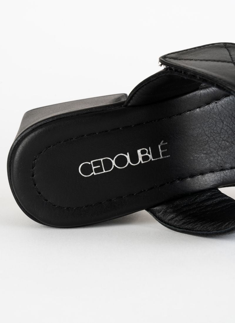 Detailfoto einer eleganten jedoch alltagstauglichen Sandalette aus Glattleder in schwarz mit weich gepolsterter Decksohle, die mit einem silberfarbenen CEDOUBLÉ Logo bedruckt ist