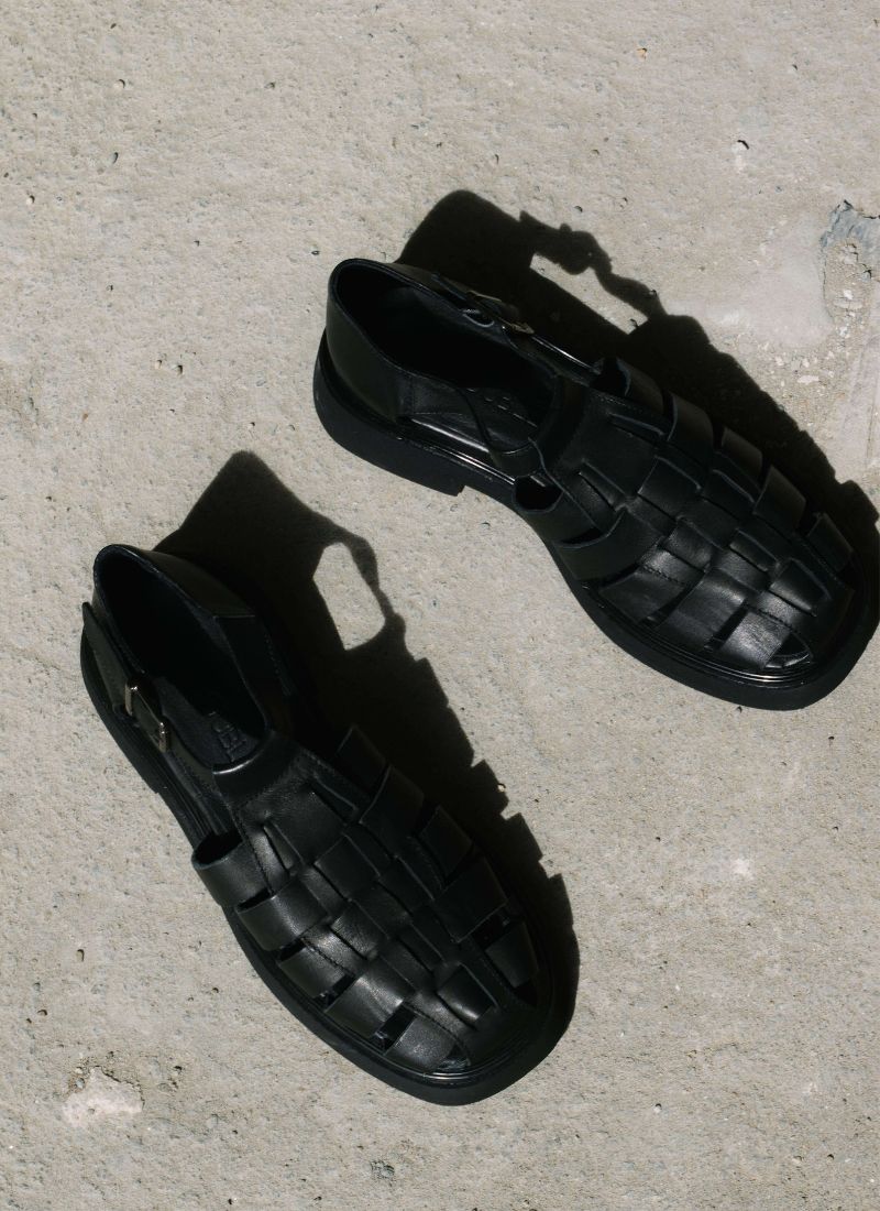 Unisex black leather fisherman sandals illuminated by the sun