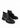 Ein Paar schwarze Chelseaboots aus Leder mit weitflächigem Elastikeinsatz und dekorativer Schnalle in Schleifenoptik. Dieses Schleifendetail schmiegt sich über den Spann.